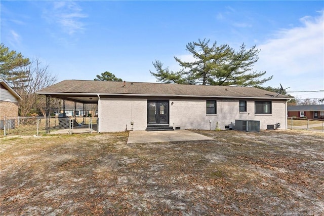 rear view of house with brick siding, a shingled roof, fence, central AC, and a patio area