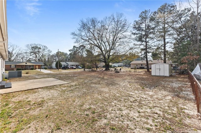 view of yard with a storage shed, cooling unit, a patio area, and an outdoor structure