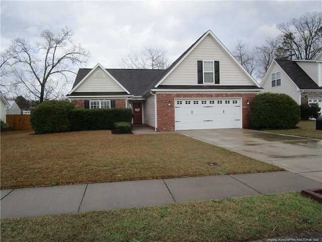 view of front of house with driveway, fence, a front yard, an attached garage, and brick siding