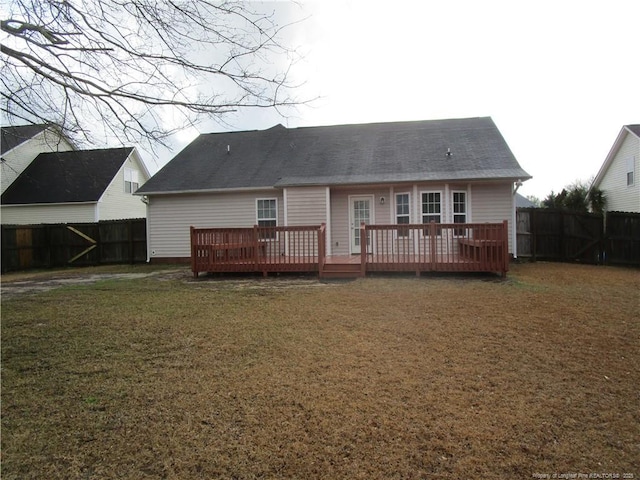 back of property featuring a yard, a wooden deck, and a fenced backyard