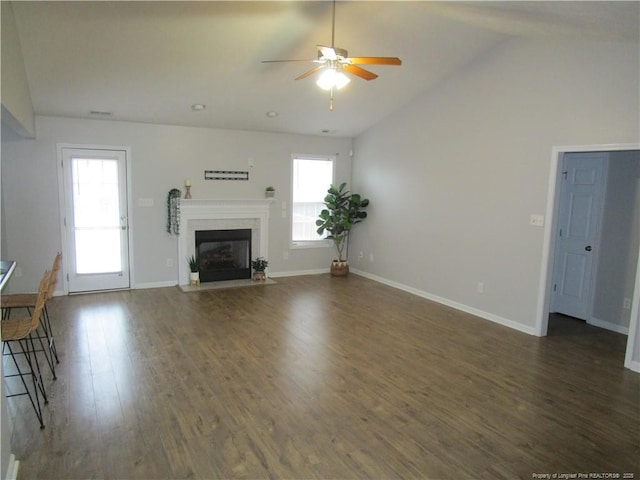 unfurnished living room featuring a fireplace with flush hearth, a ceiling fan, baseboards, dark wood-style flooring, and vaulted ceiling