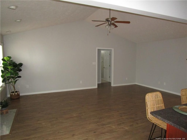 living room featuring baseboards, dark wood-type flooring, a ceiling fan, and vaulted ceiling