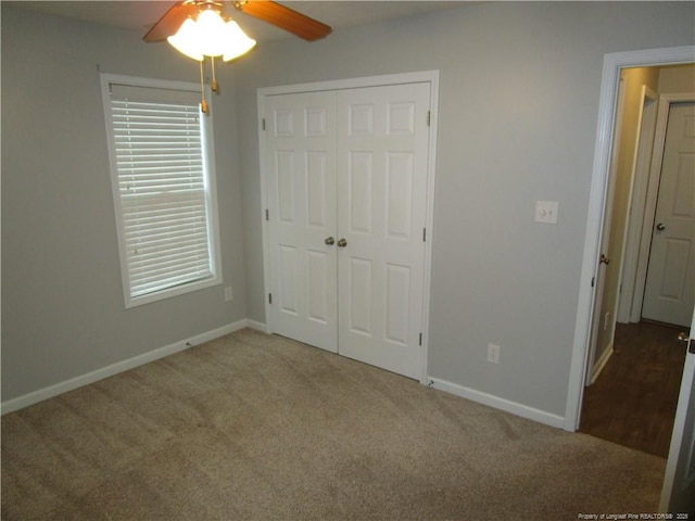 unfurnished bedroom with a closet, ceiling fan, baseboards, and carpet floors