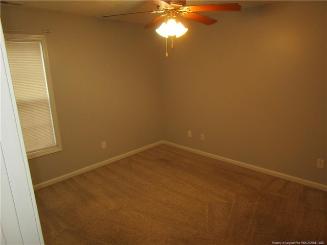 carpeted spare room with baseboards and a ceiling fan