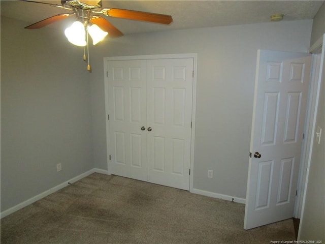 unfurnished bedroom featuring a closet, carpet flooring, a ceiling fan, and baseboards