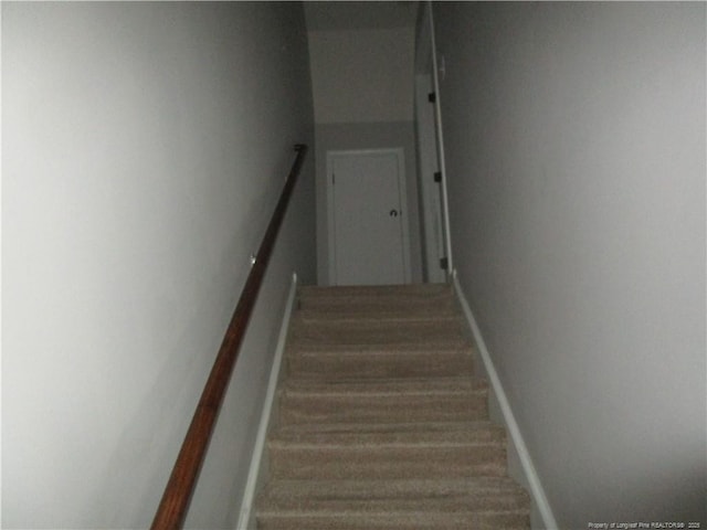 stairway featuring baseboards and wood finished floors