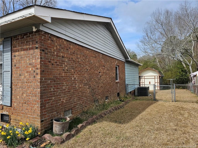 view of property exterior featuring brick siding, central air condition unit, fence, and a gate