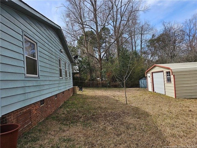 view of yard featuring an outbuilding, a storage unit, fence, and a garage