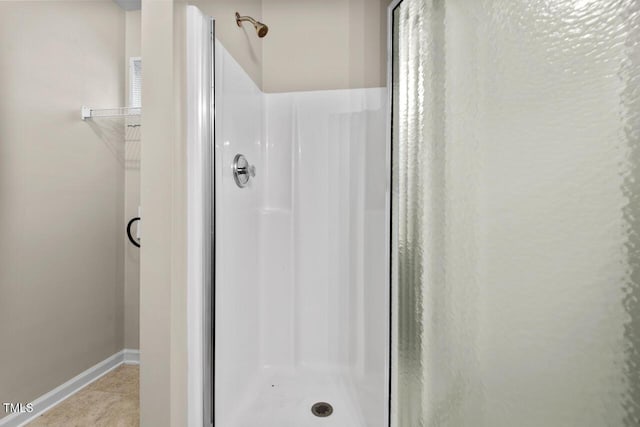 bathroom featuring baseboards and a stall shower