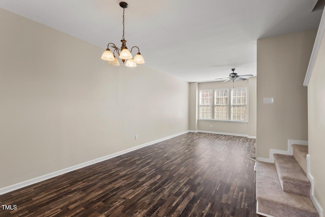 unfurnished living room with stairs, baseboards, dark wood-style floors, and ceiling fan with notable chandelier