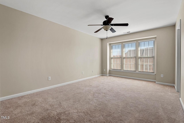 unfurnished room with ceiling fan, visible vents, baseboards, and carpet