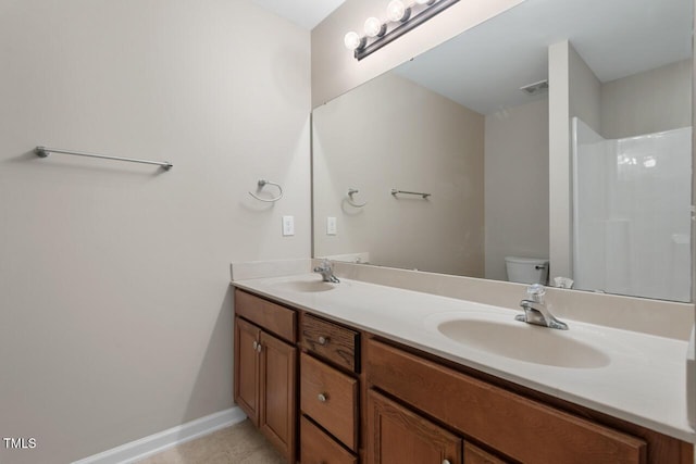full bath with double vanity, toilet, baseboards, and a sink