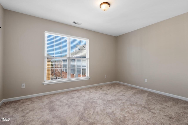 spare room featuring baseboards, carpet flooring, and visible vents