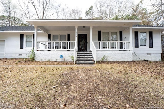 ranch-style home featuring crawl space, covered porch, an attached garage, and a shingled roof