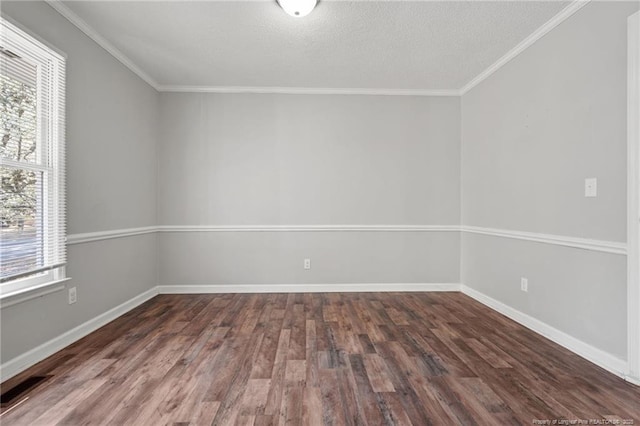 empty room featuring visible vents, baseboards, wood finished floors, and ornamental molding