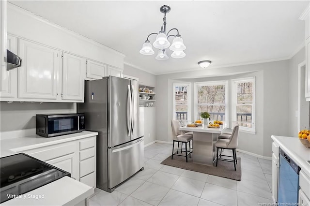 kitchen with a chandelier, light countertops, appliances with stainless steel finishes, and ornamental molding