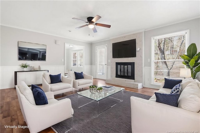 living area featuring wainscoting, a ceiling fan, and wood finished floors