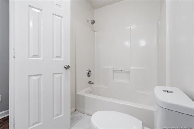 bathroom featuring toilet, washtub / shower combination, and marble finish floor