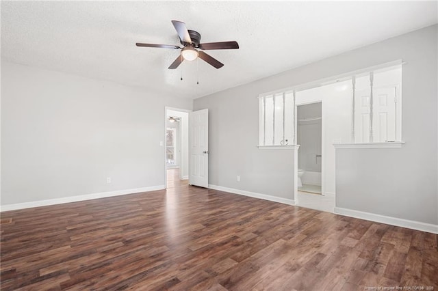 unfurnished bedroom featuring a textured ceiling, baseboards, and wood finished floors