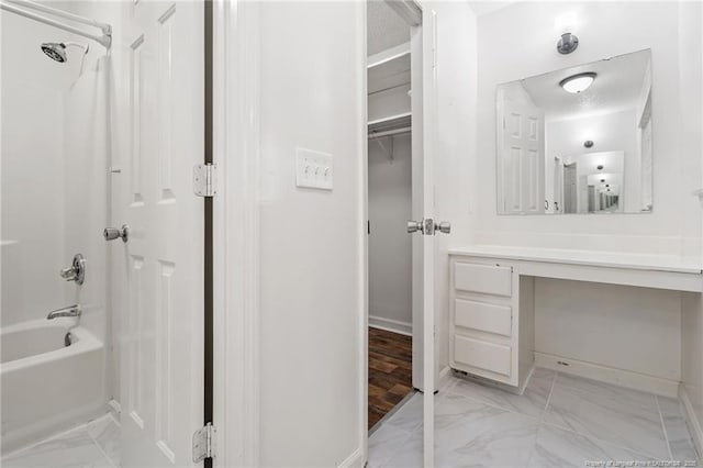 bathroom with baseboards, marble finish floor, bathtub / shower combination, and vanity