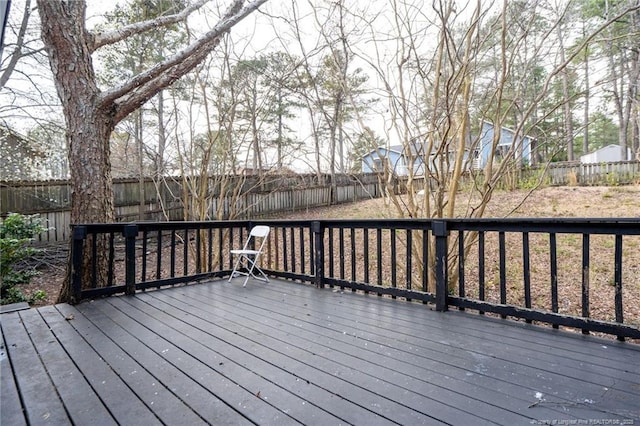 wooden deck with a fenced backyard