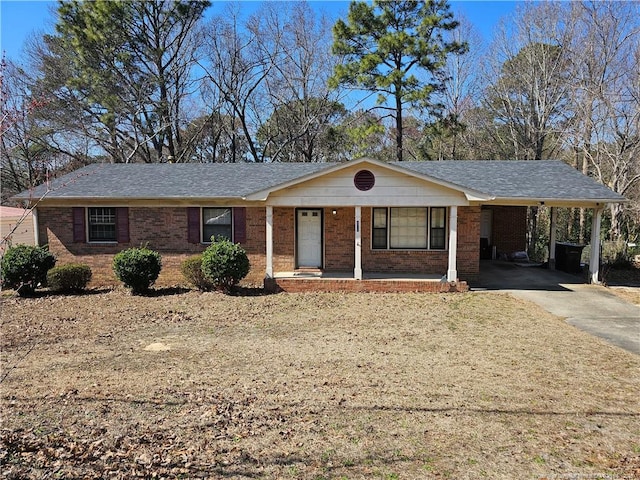 single story home with driveway, a carport, covered porch, roof with shingles, and brick siding