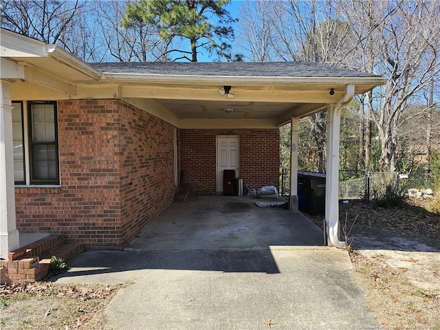 view of parking with a carport, driveway, and fence