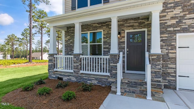 3040 Platinum Cir W, End, NC 27376 - property entrance with a porch, stone siding, a yard, and a garage