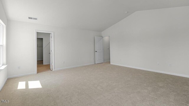 3040 Platinum Cir W, End, NC 27376 - unfurnished bedroom featuring lofted ceiling, light colored carpet, a walk in closet, and multiple windows