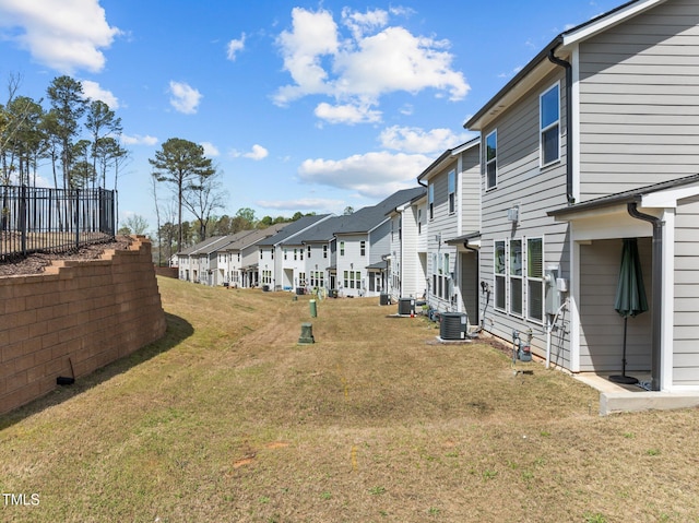 view of yard with central AC unit and a residential view
