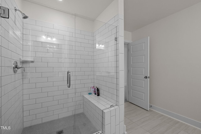 bathroom with baseboards and a stall shower
