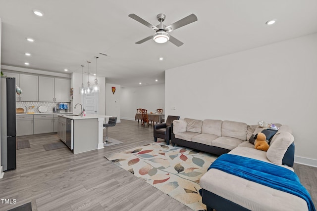 living room with recessed lighting, light wood-style flooring, baseboards, and ceiling fan