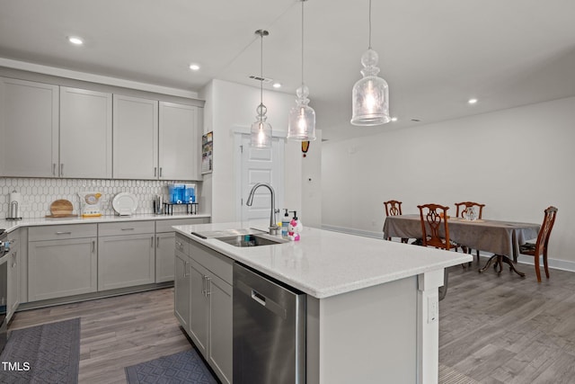 kitchen featuring a sink, tasteful backsplash, gray cabinetry, and dishwasher