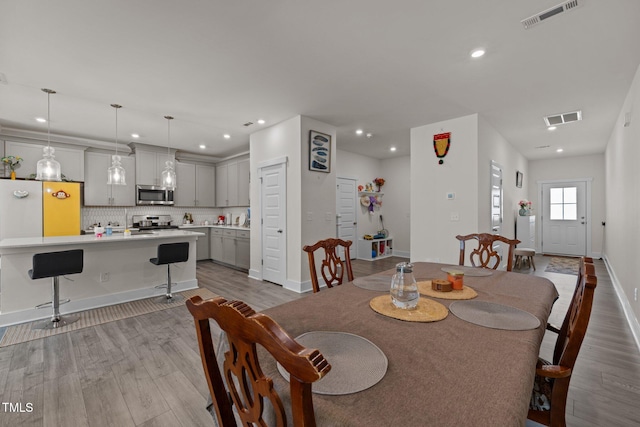 dining area with recessed lighting, visible vents, and wood finished floors