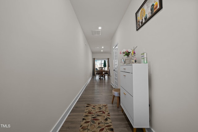 corridor featuring wood finished floors, baseboards, visible vents, and recessed lighting