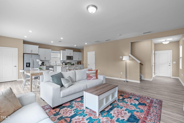 656 Dallas Rose Dr, Wendell, NC 27591 - living room with light wood-style flooring, baseboards, stairway, and recessed lighting