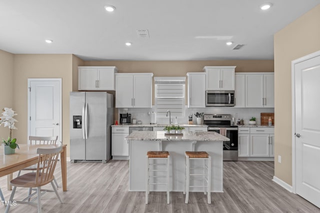 656 Dallas Rose Dr, Wendell, NC 27591 - kitchen with a center island, appliances with stainless steel finishes, decorative backsplash, and visible vents