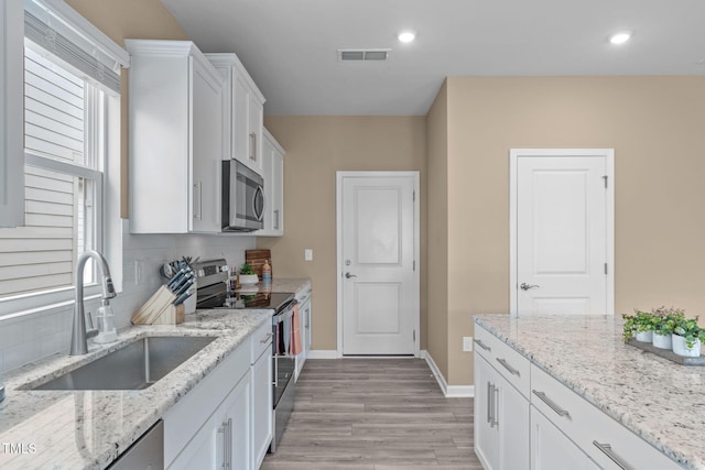 656 Dallas Rose Dr, Wendell, NC 27591 - kitchen featuring white cabinets, visible vents, decorative backsplash, stainless steel appliances, and a sink