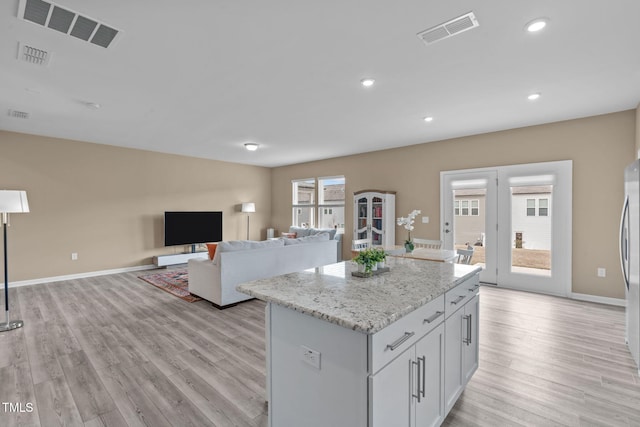 656 Dallas Rose Dr, Wendell, NC 27591 - kitchen with visible vents, light wood-type flooring, light stone counters, and a kitchen island
