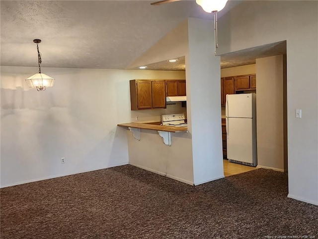 kitchen featuring lofted ceiling, white appliances, light colored carpet, and brown cabinets