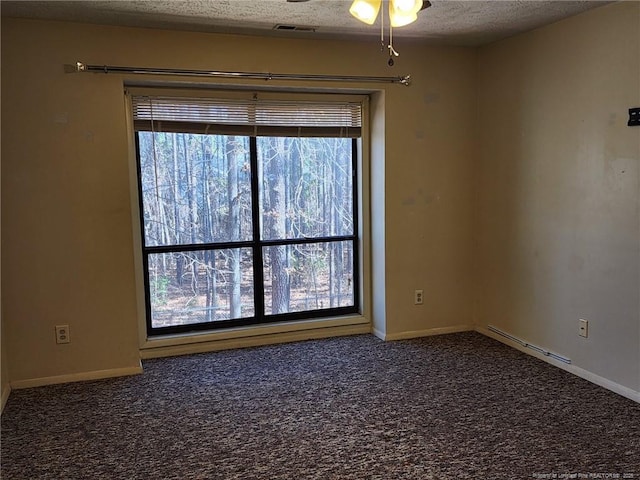 spare room with visible vents, a ceiling fan, a textured ceiling, carpet, and baseboards