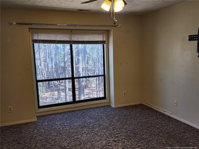 spare room with visible vents, baseboards, ceiling fan, carpet flooring, and a textured ceiling