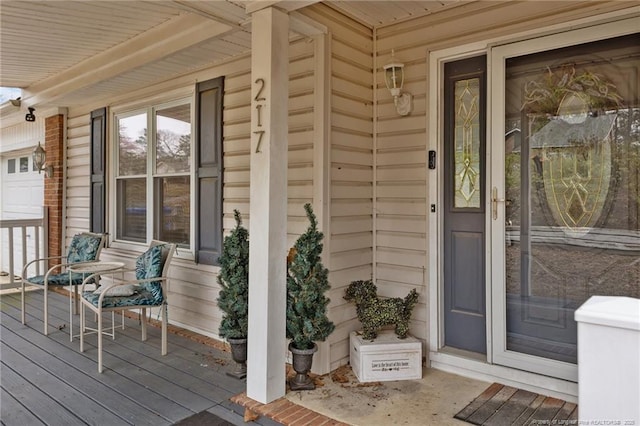 doorway to property with a garage and covered porch