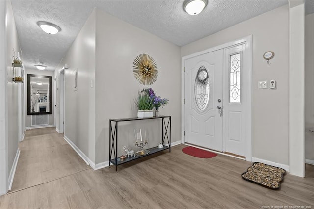 entrance foyer featuring wood finished floors, baseboards, and a textured ceiling