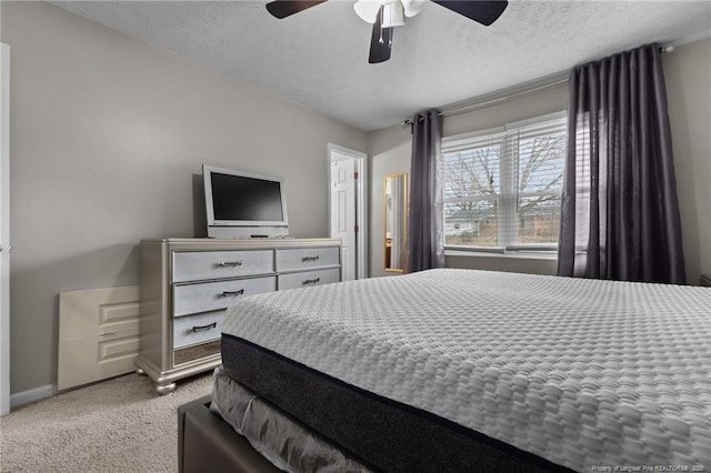 carpeted bedroom with ceiling fan, baseboards, and a textured ceiling