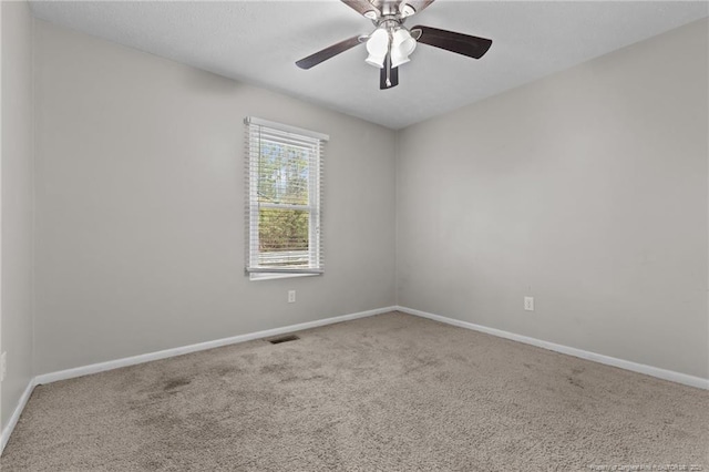 carpeted spare room with visible vents, ceiling fan, a textured ceiling, and baseboards