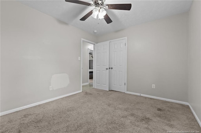 unfurnished bedroom with baseboards, ceiling fan, a closet, a textured ceiling, and carpet flooring