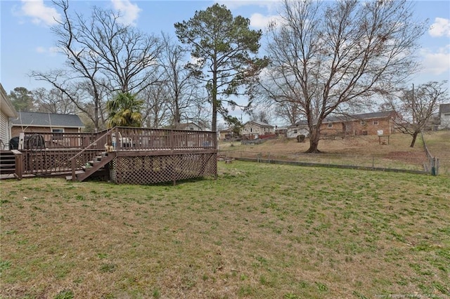 view of yard featuring a wooden deck, fence, and stairway