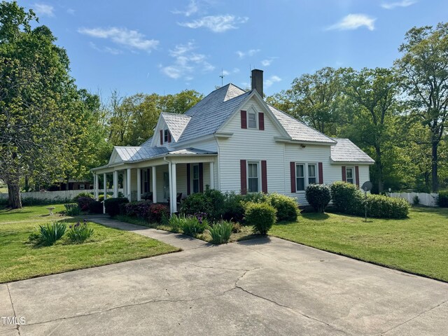 4715 Jacksontown Rd, Manson, NC 27553 - farmhouse-style home featuring a front yard, fence, a chimney, and covered porch