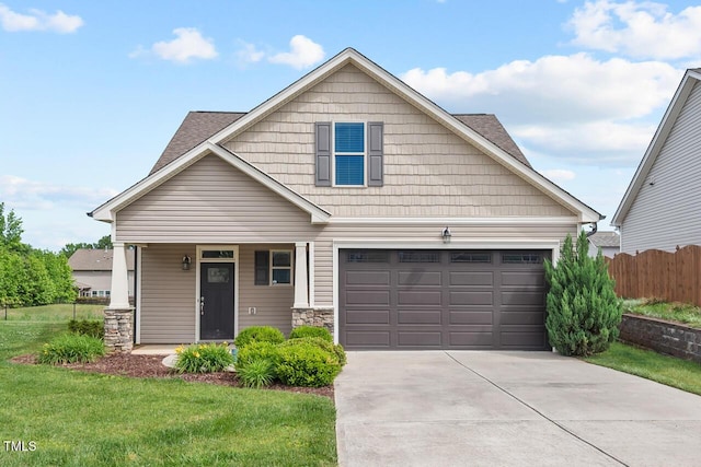 view of front of house with driveway, a garage, a porch, and stone siding